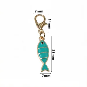 Detail view of the teal enamel fish pendant charm with gold lobster clasp, close-up shot.