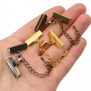 Close-up of DIY jewelry findings with metal cord clamps, lobster clasps and extension chains.