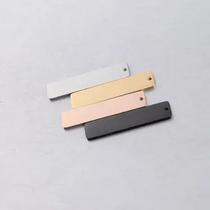 Primo piano di quattro ciondoli rettangolari in acciaio inossidabile per gioielli DIY.