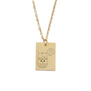 Gros plan d'un collier pendentif rectangulaire doré avec un chat mignon gravé dans un pot.