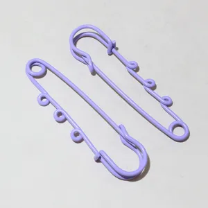 Detail shot of purple safety pins with hanging loops, ideal for DIY doll pendants.