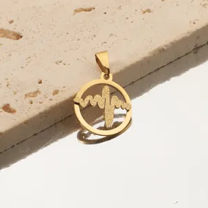 Gros plan détail d'un pendentif rond plaqué or motif battement de coeur accessoire.