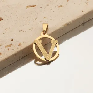 Gros plan sur l'accessoire pendentif lettre V découpée doré avec texture givrée.