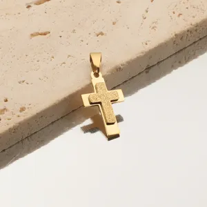 Détail du pendentif croix dorée, finition givrée, accessoire de bijoux pour colliers.
