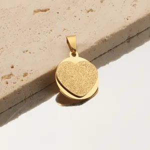 Gros plan du pendentif cœur doré et givré montrant une texture détaillée et finition.