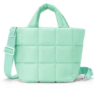 Dettaglio borsa tracolla trapuntata verde menta, motivo a griglia, cinturino e fibbia metallo.