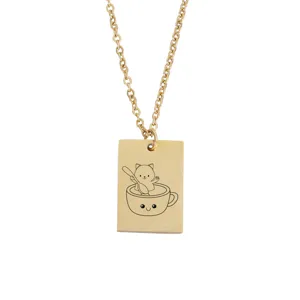 Gros plan détaillé du pendentif rectangle doré gravé représentant un chat mignon.