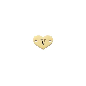 Primo piano di un ciondolo cuore in acciaio dorato con lettera V e fori per gioielli fai da te.