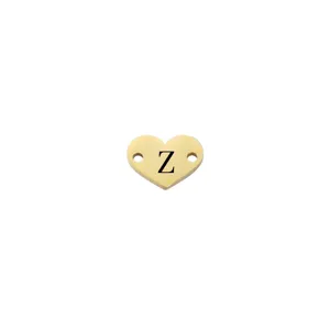 Dettaglio charm cuore in acciaio inossidabile, finitura specchio oro con lettera Z inciso.