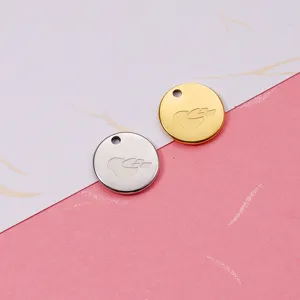Close-up detail of stainless steel round disc jewelry pendants, featuring engraved birds.
