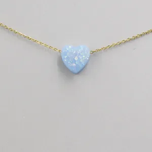 Close-up of light blue heart opal pendant necklace with delicate gold chain details.