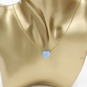 Detailed close-up of gold chain necklace featuring a cute light blue heart opal pendant.