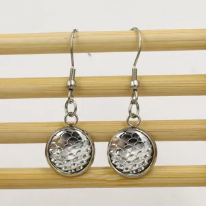 Detailed close-up of stainless steel round earrings featuring a shiny fish scale pattern.