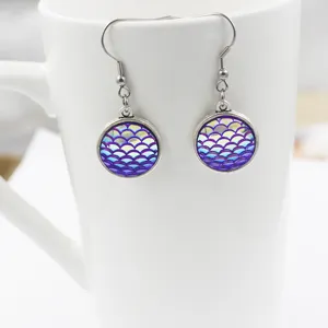 Detailed close-up of purple mermaid scale earrings with stainless steel hooks and resin pendants.