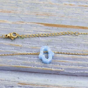 Gold-plated stainless steel necklace featuring a light blue opal hamsa hand pendant.