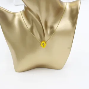 Gold stainless steel clavicle chain featuring a vibrant yellow resin hamsa hand pendant.