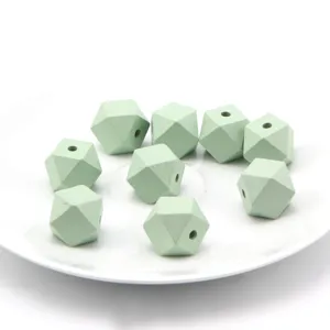 Faceted wooden beads close-up, light green geometric design, perfect for DIY jewelry craft.