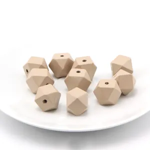 Close-up view of geometric wooden beads on white plate, perfect for handmade DIY jewelry crafting.