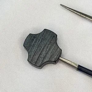 Detail shot of natural ebony wood cross spacer bead showing fine texture and carved lines.
