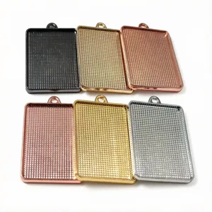 Close up of rectangular pendant trays, multi-color alloy blank bezel bases for DIY jewelry.