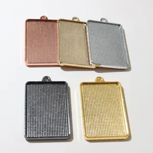 Close up of rectangular metal pendant trays with grid texture, multi-color DIY jewelry base.