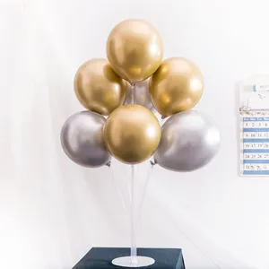 Vue détaillée du support à ballons transparent avec des ballons dorés et argentés.