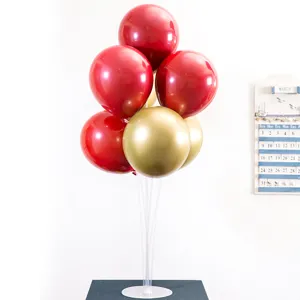 Détail de support de ballon de table avec tiges transparentes et ballons de fête rouges.
