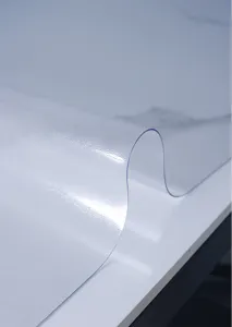 Detailed shot of clear transparent PVC soft glass tablecloth showing thickness and texture.