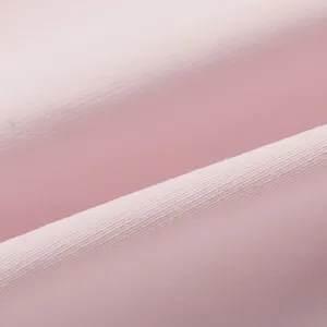 Gros plan d'un tissu en soie glacée rose doux montrant une texture tricotée et un design respirant.