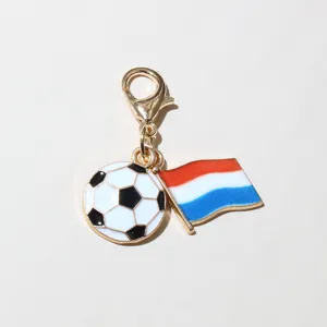 Detailed view of metal enamel soccer ball and flag charm pendant with lobster clasp for DIY.