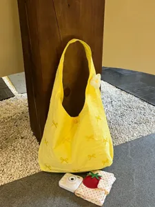 Yellow embroidered tote bag with bow details, large capacity casual shoulder bag detail view.