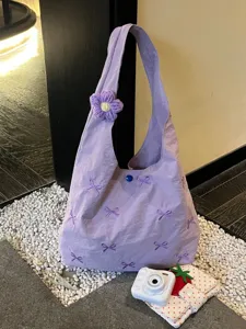 Purple hobo shoulder bag with cute bow embroidery and knitted flower pendant for daily commute.