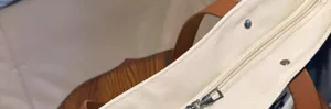 Canvas tote bag detail zipper and strap close up view sturdy construction beige and brown