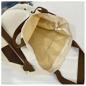 Détail intérieur de sac cabas en toile, grand sac bandoulière décontracté avec poche zippée.