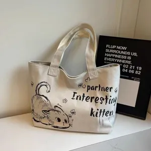 Close-up detail view of casual canvas tote bag featuring cute cat graphic and print.