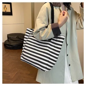 Detail view of stylish black and white striped canvas tote bag, large capacity design.