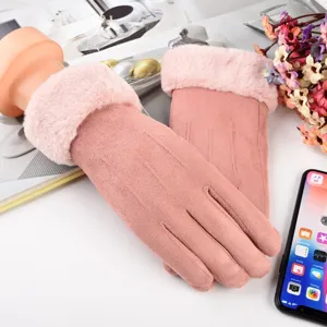 Close-up of pink suede winter touchscreen gloves with plush faux fur cuffs on scenic background.