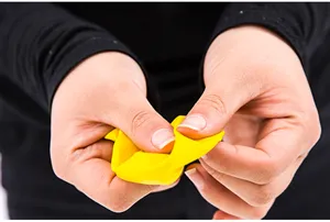 Vue en gros plan du test d'élasticité du matériau en latex jaune pour une décoration de fête durable.