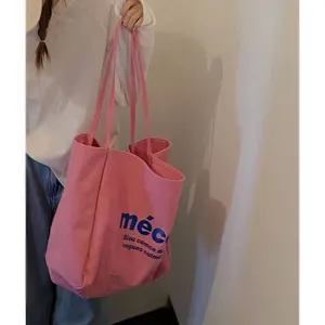 Pink canvas tote bag detail view, casual shoulder bag with blue letter print for daily use.