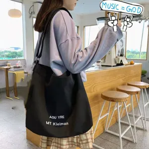 Detailed view of a black canvas large capacity tote bag with stylish print for daily use.