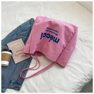 Pink canvas shoulder bag detail view, casual commuter style with blue printed letters.