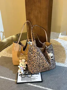 Detailed view of large capacity leopard print canvas tote bag with cute charms and casual style.