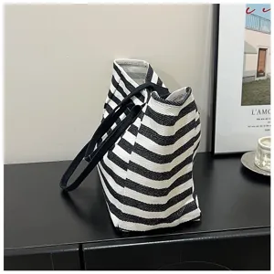 Close-up detail of black and white striped canvas tote bag, large capacity shoulder design.