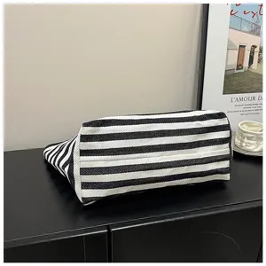 Detailed view of black and white striped canvas tote bag showing bottom gusset design.