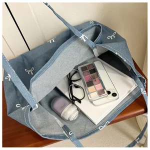 Denim canvas tote bag detail view showing large capacity and interior organization with items.