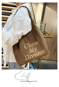 Detailed view of the brown nylon tote bag featuring stylish embroidered letter design.