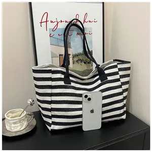 Black and white striped canvas tote bag, large capacity casual commuter handbag detail view.