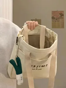 Canvas tote bag for women, large capacity shoulder bag, casual commuting student bag detail view.