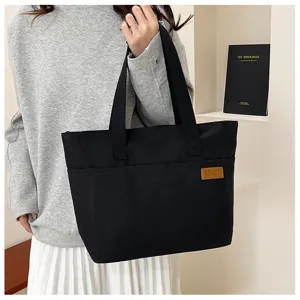 Vue détaillée du sac cabas en toile noire, grande capacité, style de pendulerie décontracté.