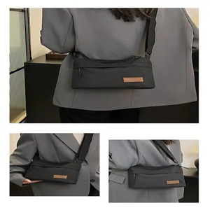 Detail shot of black multi-layer canvas crossbody shoulder bag with compartments for daily use.